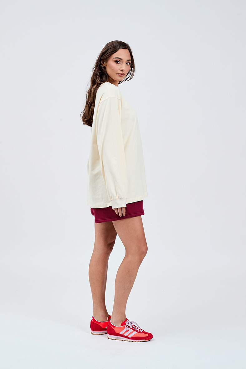 right side view of butter yellow long sleeve top with burgundy shorts