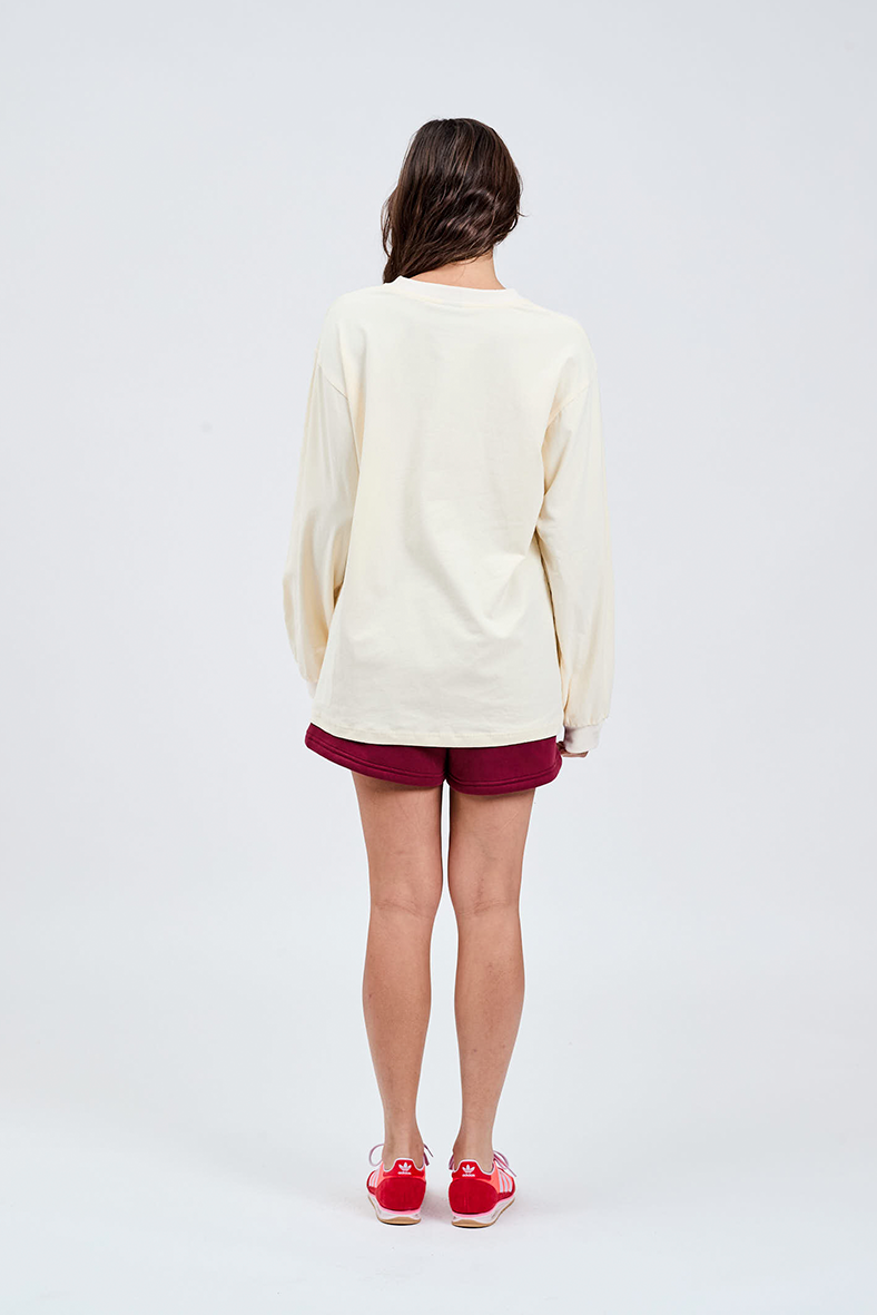 back view of butter yellow long sleeve top with burgundy shorts 