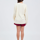 back view of butter yellow long sleeve top with burgundy shorts 