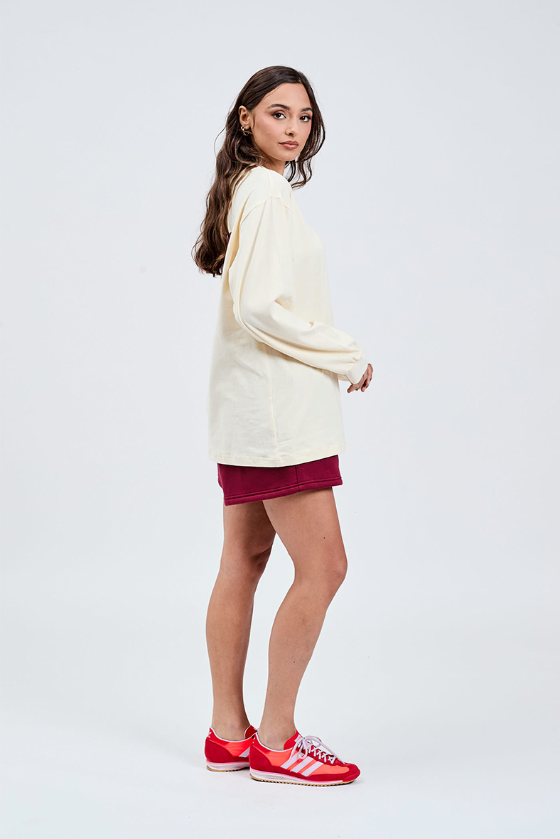 side view of ciao butter yellow long sleeve crew neck t-shirt with burgundy shorts