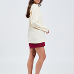 side view of ciao butter yellow long sleeve crew neck t-shirt with burgundy shorts