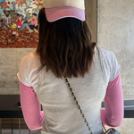 Person wearing a cap with 'Liberta' logo, standing indoors with a colorful mural in the background.