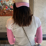 Person wearing a cap with 'Liberta' logo, standing indoors with a colorful mural in the background.