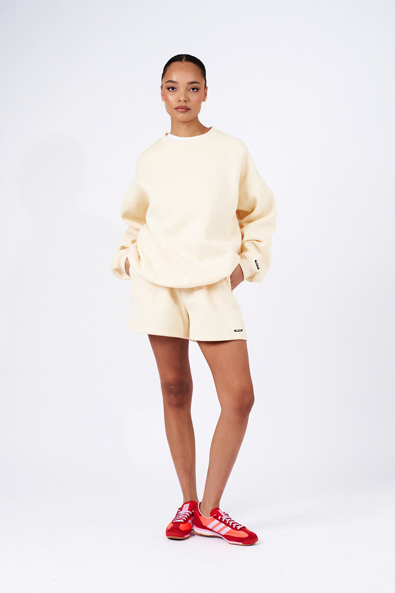 butter yellow oversized crew neck jumper with matching butter yellow shorts and red sneakers