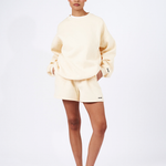 butter yellow oversized crew neck jumper with matching butter yellow shorts and red sneakers