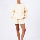 butter yellow oversized crew neck jumper with matching butter yellow shorts and red sneakers