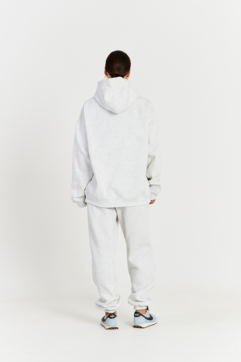 back of grey hoodie with matching grey track pants cuffed at the ankle
