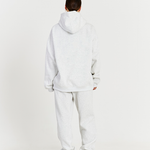 back of grey hoodie with matching grey track pants cuffed at the ankle