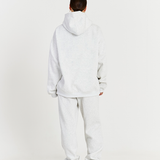back of grey hoodie with matching grey track pants cuffed at the ankle