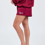 burgundy cotton shorts close up with embroidered cream italic text saying tully lou on lower left hand side 