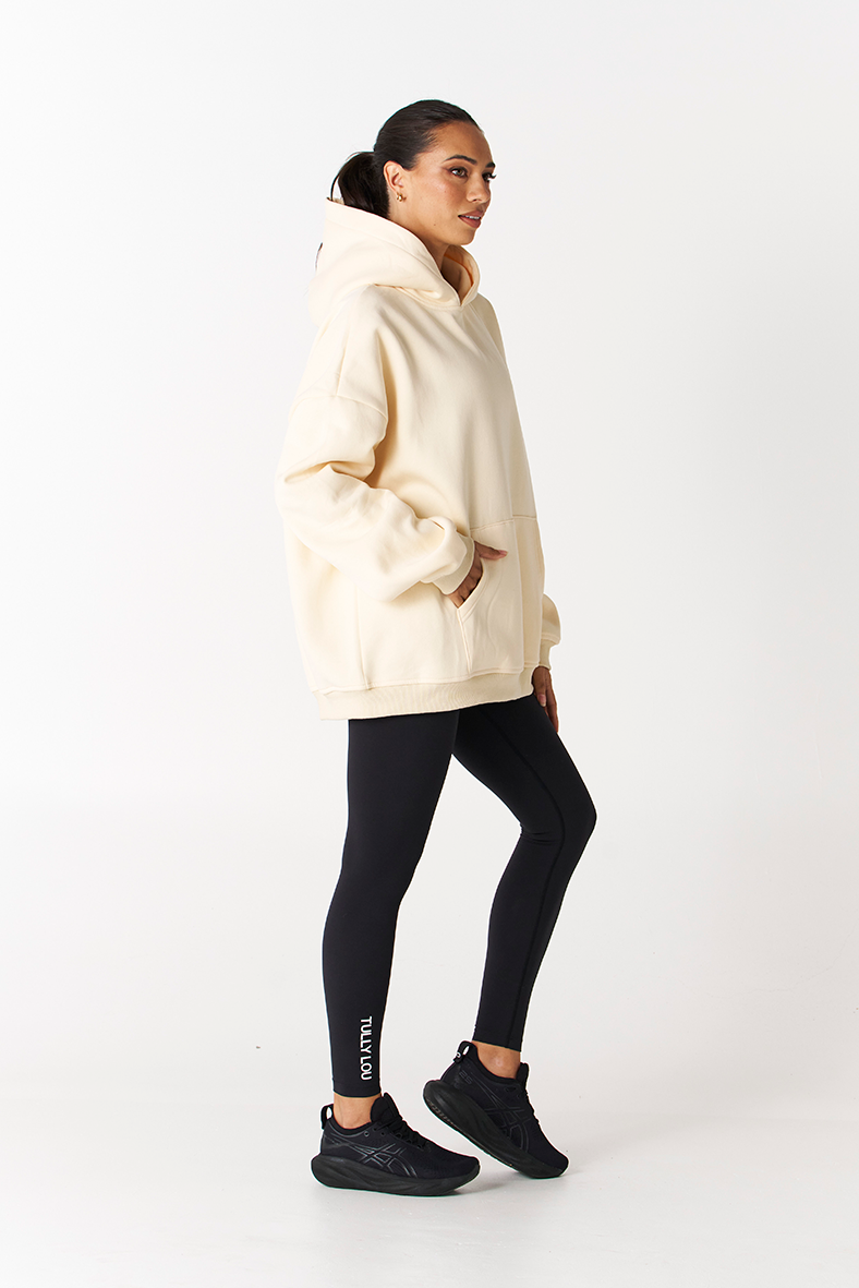 side pocket angle of butter yellow fairfax hoodie by Tully Lou with black seamless leggings compression active pant