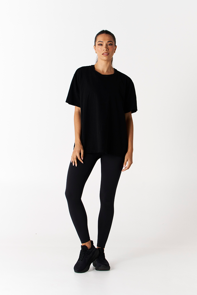 front view of heavy weight black cotton tee with print logo on back and black wide waistband compression leggings Tully Lou
