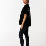 Side view of heavy weight cotton oversized black tee with black leggings with no front seam and wide waistband compression pants by Tully Lou