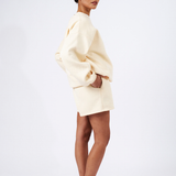 size view of model with hand in pocket wearing essential lounge set crew neck jumper and shorts