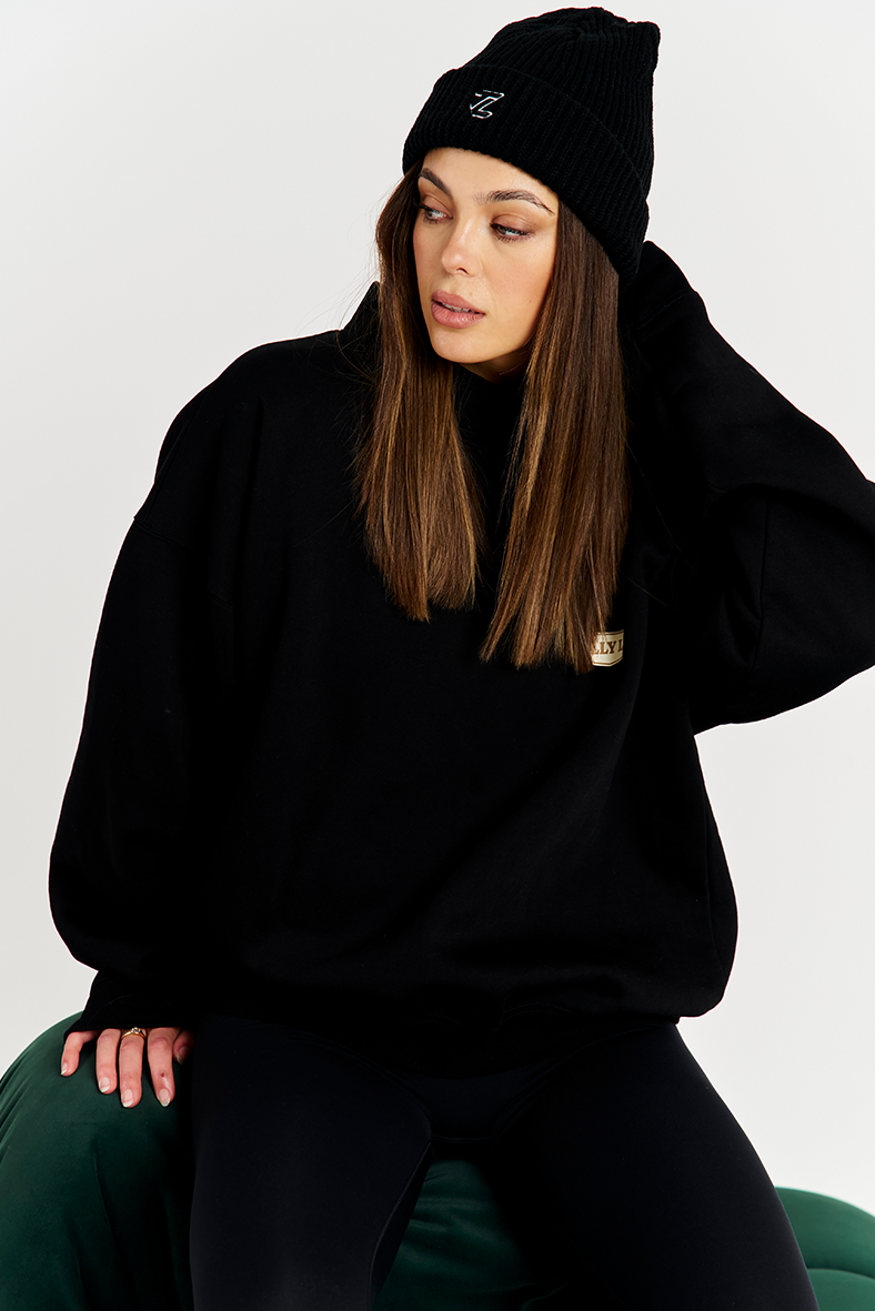 Black beanie with black round neck jumper and black leggings 