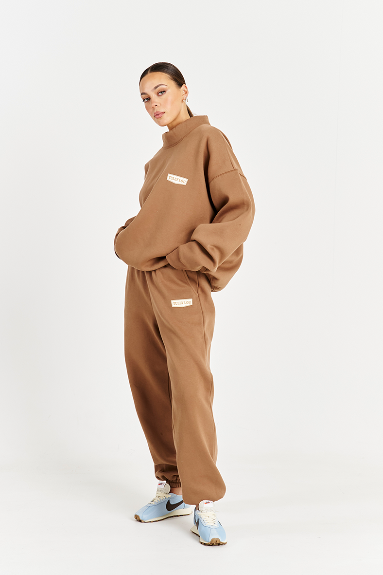 side left image model wearing mocha brown high neck cotton fleece jumper and matching track pants 