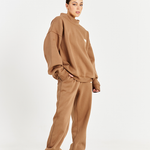 model wearing matching mocha brown track pants and brown jumper with high neck