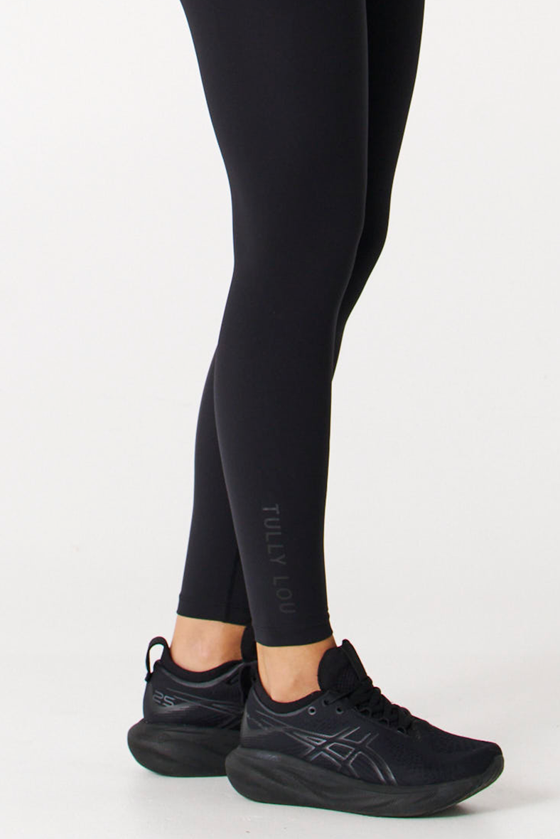 Tully lou logo on lower ankle of black workout leggings with high waisted core support 