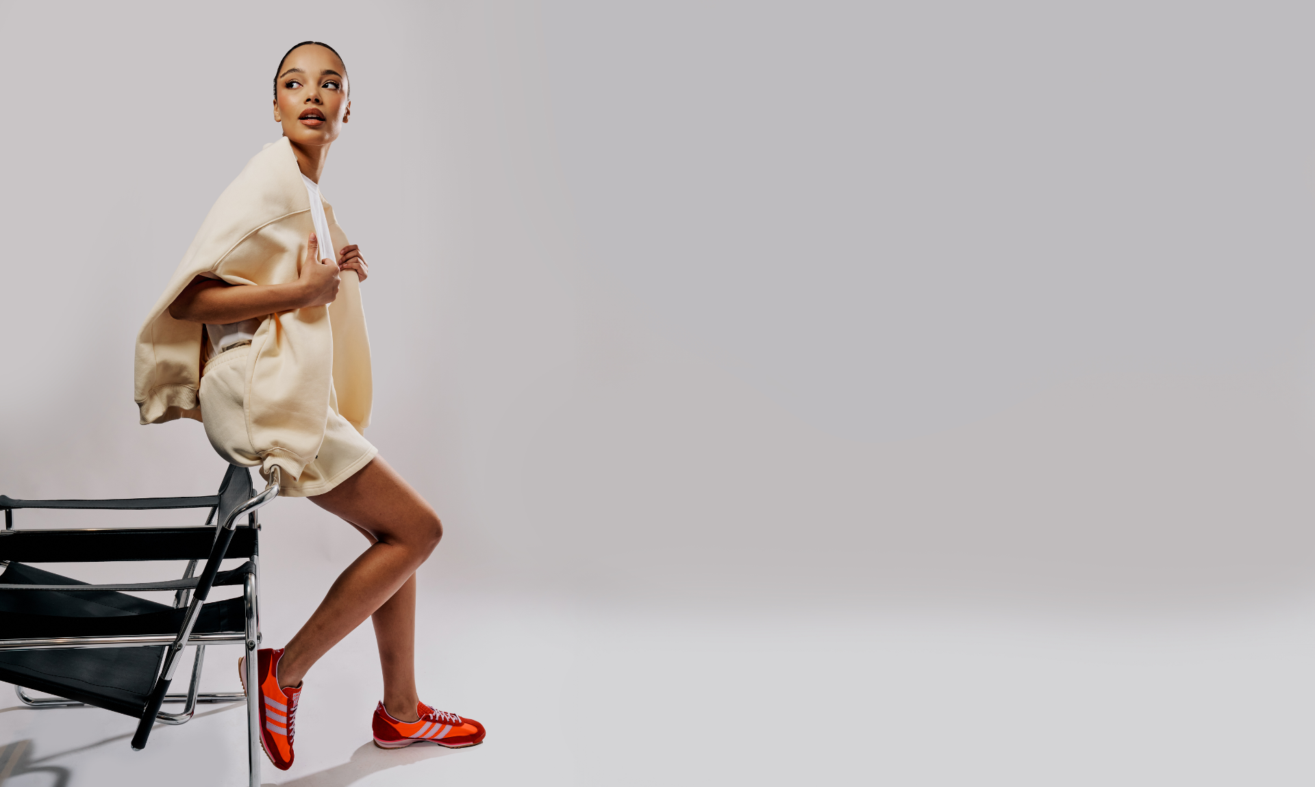 model leaning on a chair with butter yellow matching shorts and crew neck jumper on