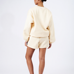 back view of model wearing butter yellow shorts and oversized boyfriend sweater 