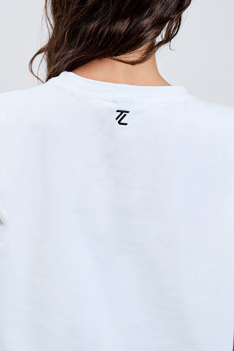 back close up of essential white tee with TL logo embroidered black 