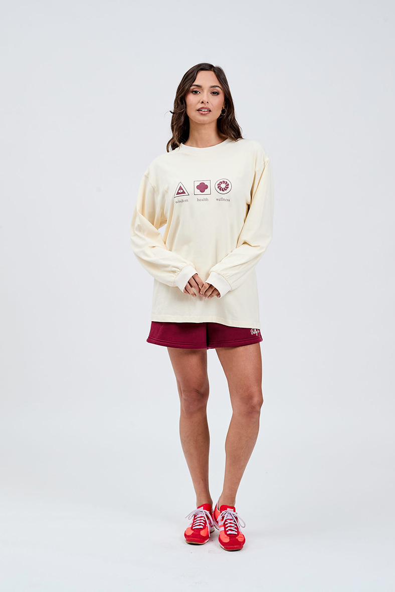 Butter yellow long sleeve crew tee with wisdom health and wellness printed in burgundy centre from styled with burgundy shorts