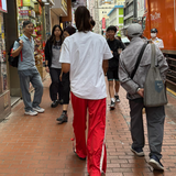 red track pants with people walking in hong kong