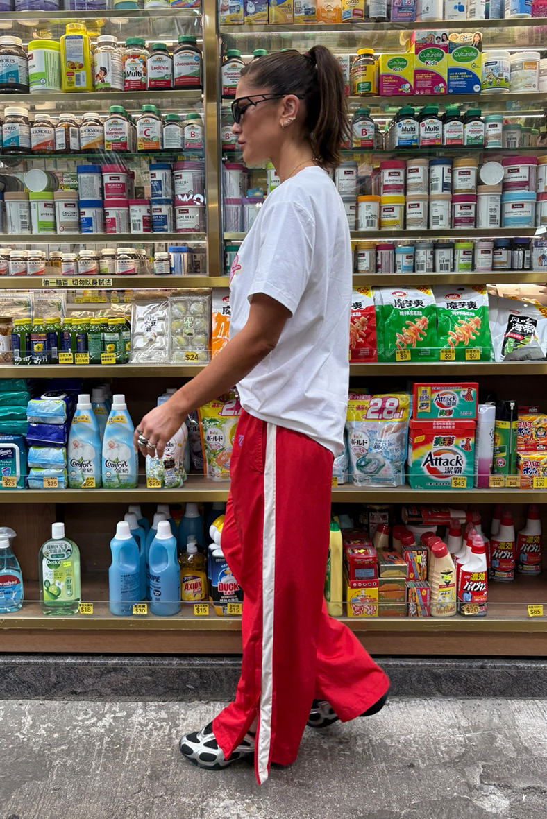 Person standing in a store aisle with shelves stocked with various products