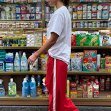 Person standing in a store aisle with shelves stocked with various products