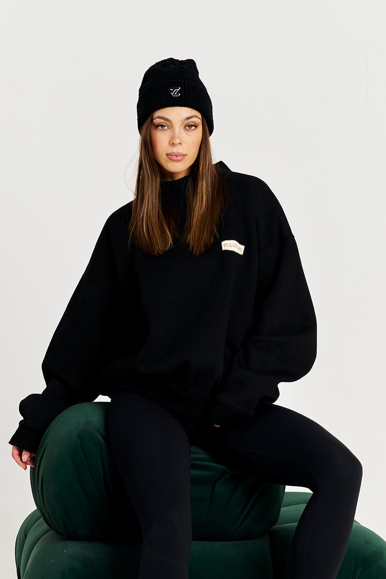 black beanie model on green couch with black tracksuit set 