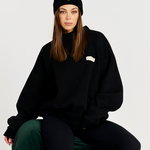 black beanie model on green couch with black tracksuit set 