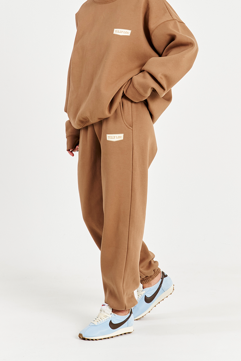close up side image of mocha brown track pants with left hand side pocket and Tully Lou logo 