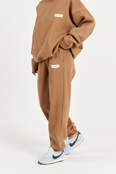close up side image of mocha brown track pants with left hand side pocket and Tully Lou logo 